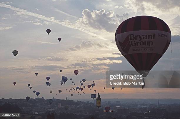 Hot air balloons pass the Severn Bridge during the Bristol International Balloon Fiesta at the Ashton Court Estate on 15 August 1990 in Bristol,...