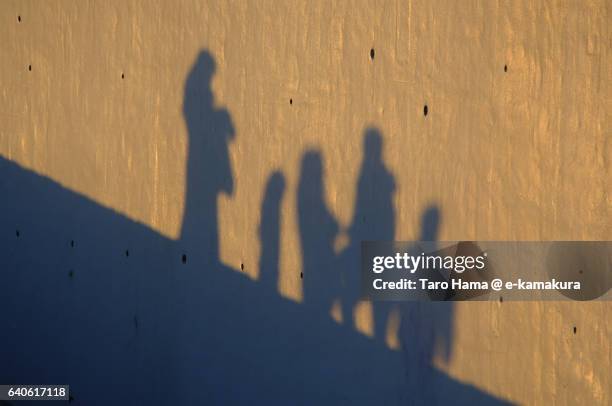 a family silhouette reflected on the wall on the sunset beach - wall e stock pictures, royalty-free photos & images