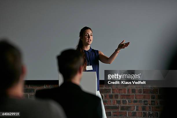 businesswoman doing presentation at convention - discorso foto e immagini stock