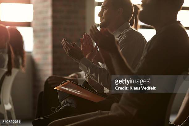 group of businesspeople clapping at lecture - business conference auditorium stockfoto's en -beelden