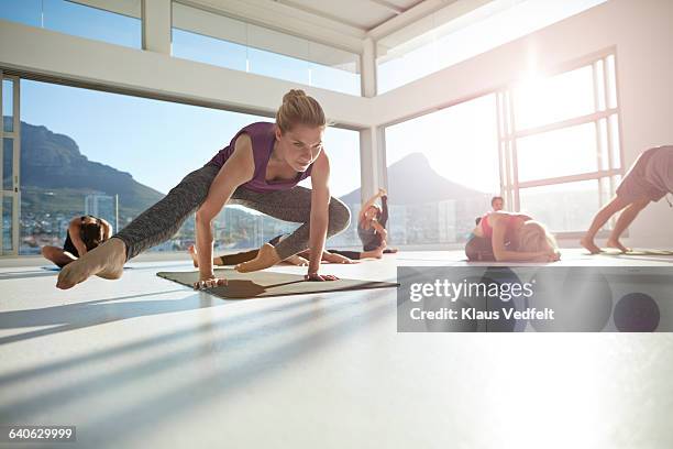 woman doing yoga balance exercise - woman straddling man stock pictures, royalty-free photos & images