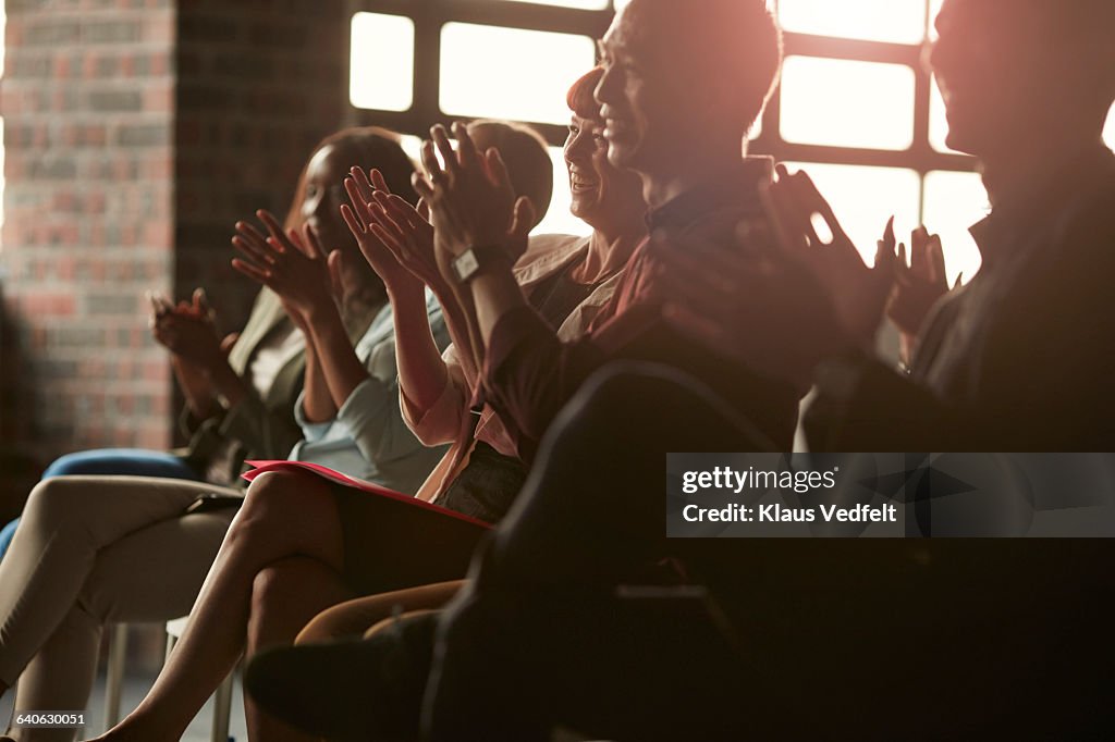 Group of businesspeople clapping at lecture