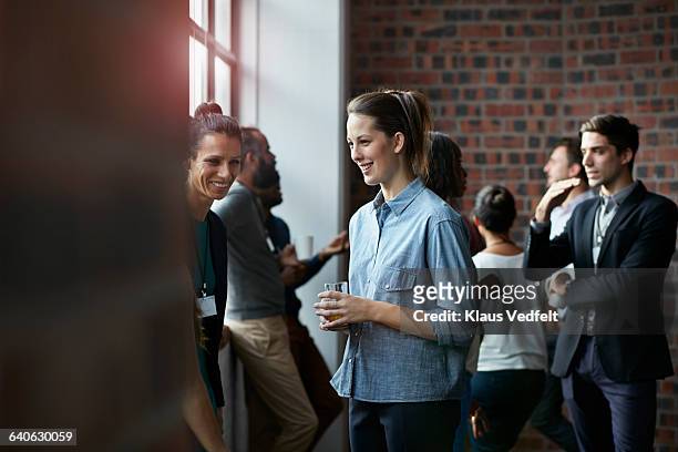 Businesspeople socializing by window of auditorium
