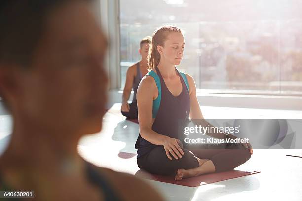 woman meditating at yoga class - yoga studio stock pictures, royalty-free photos & images