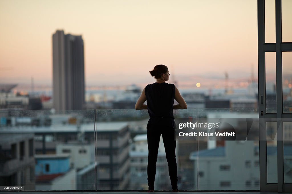 Woman enjoying view from penthouse apartment