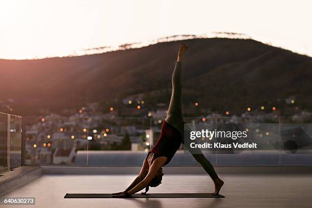 woman stretching on yoga mat, at sunset - woman stretching sunset stockfoto's en -beelden
