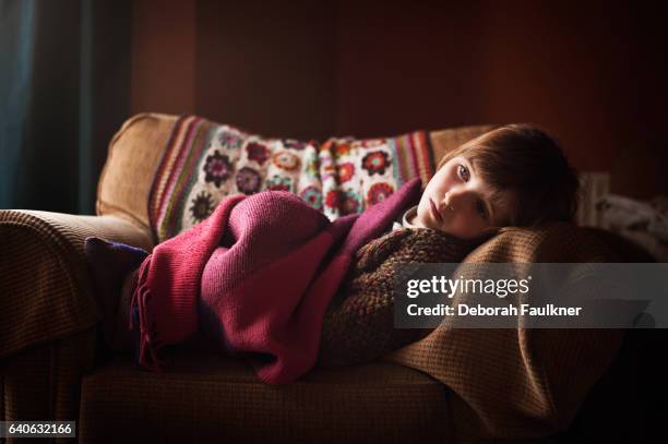 small serious girl lounging on comfortable chair - krank stock-fotos und bilder