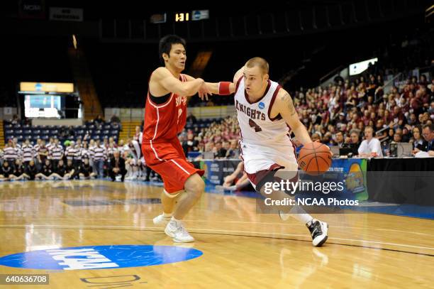 Jeremy Kendle of Bellarmine University drives to the hoop against Jet Chang of BYU-Hawaii during the Division II Men's Basketball Championship held...