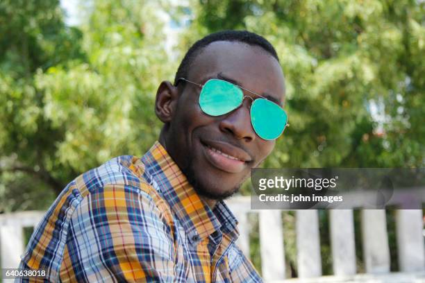 a young person smiling with his glasses - une seule personne stock pictures, royalty-free photos & images