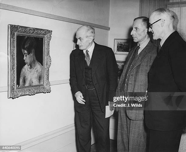 From left to right, Frank Lambert, director of the Walker Art Gallery in Liverpool, F. M. S. Winand, and Sir Edward Marsh examine a painting by...