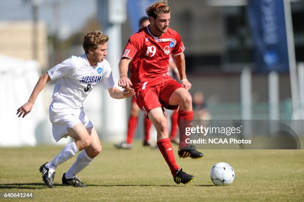 Geoff Pezon of Messiah College tries to dispossess Tyler Romano of Lynchburg College during the Division III Men's Soccer Championship held at...