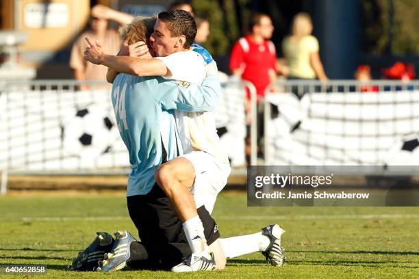Zarek Valentin of the University of Akron embraces goalie David Meves after their victory over the University of Louisville during the Division I...