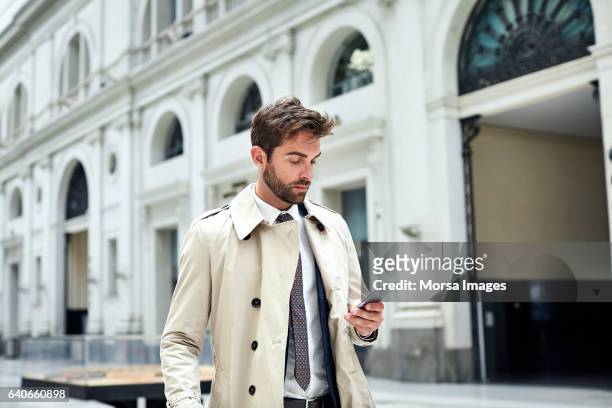 businessman using smart phone at railroad station - solo un uomo di età media foto e immagini stock