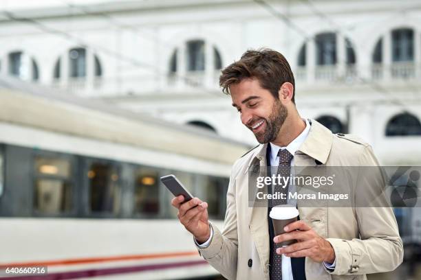 happy businessman with phone and coffee at station - man phone platform stock pictures, royalty-free photos & images