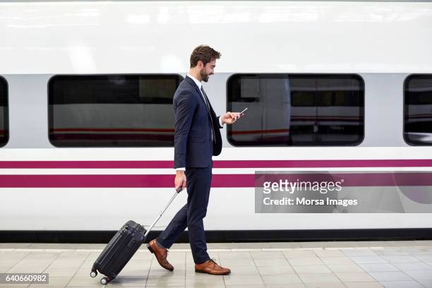 sidovy av affärsman med telefon på station - train platform bildbanksfoton och bilder