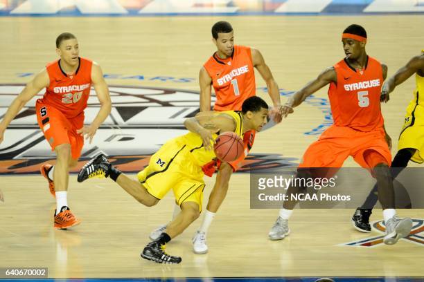 Trey Burke of University of Michigan takes on Brandon Tiche , Michael Carter-Williams and C.J. Fair of Syracuse University during the 2013 NCAA...