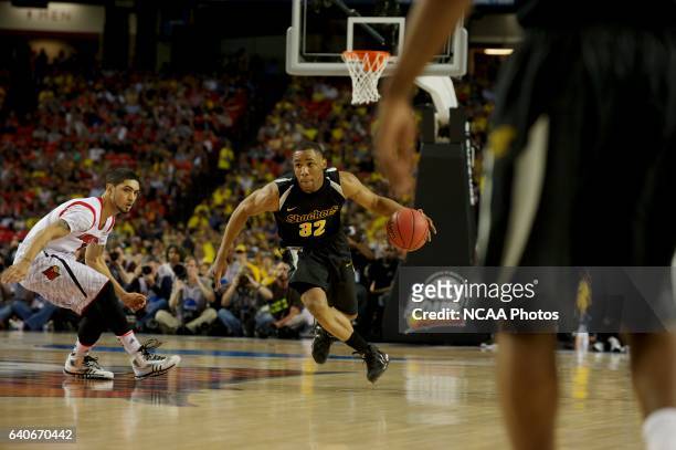 Tekele Cotton of Wichita State University drives down court next to Peyton Siva of the University of Louisville during semifinal game of the 2013...