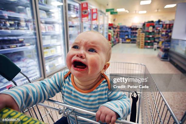 baby crying in shopping trolley - baby crying photos et images de collection