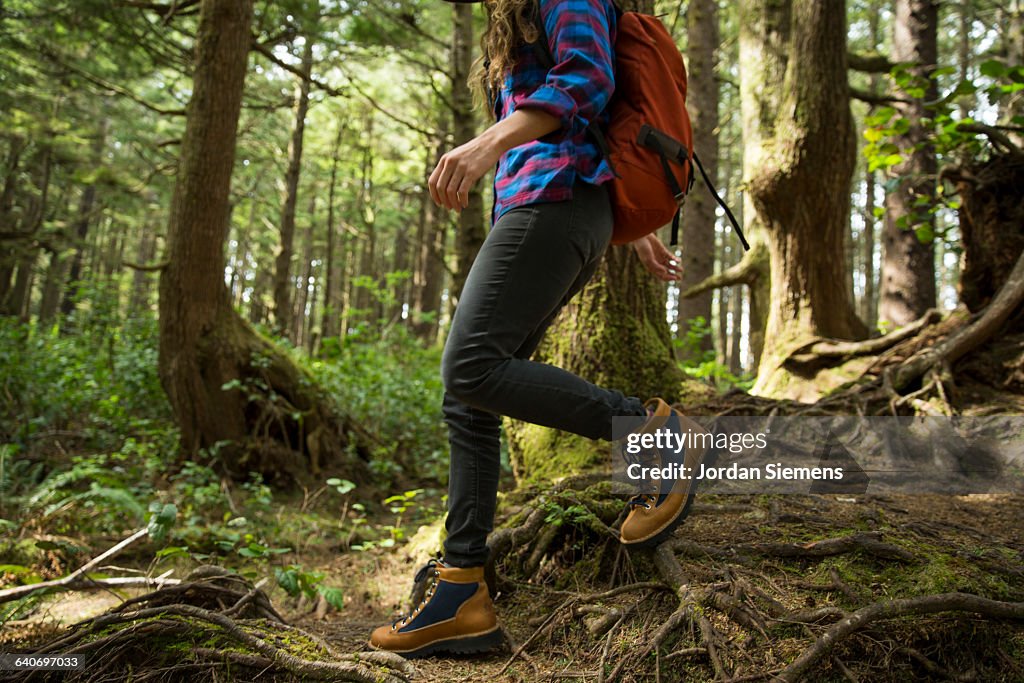 A woman hiking in a dense forest.