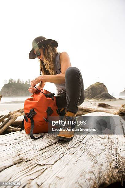 a woman hiking along a remote beach. - man tying tie stock-fotos und bilder