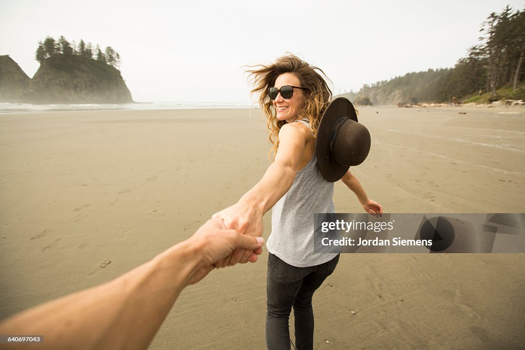 A woman hiking along a remote beach.