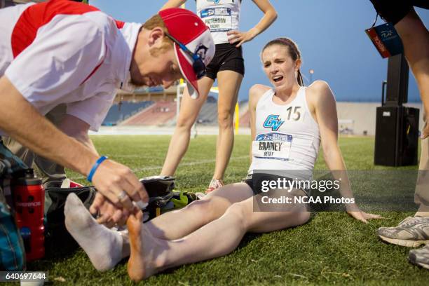 Betsy Graney of Grand Valley State University winces in pain as a trainer rinses her foot after she lost her shoe in the Women's 5000 Meter run...