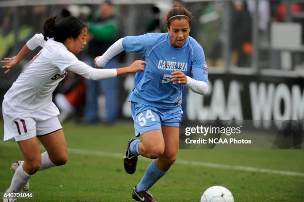 Casey Nogueira of the University of North Carolina dribbles past Rachel Quon of Stanford University during the Division I Women's Soccer Championship...