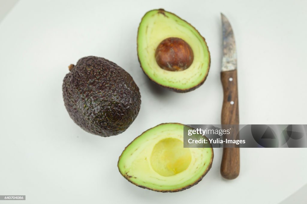 Fresh whole and halved avocado pears