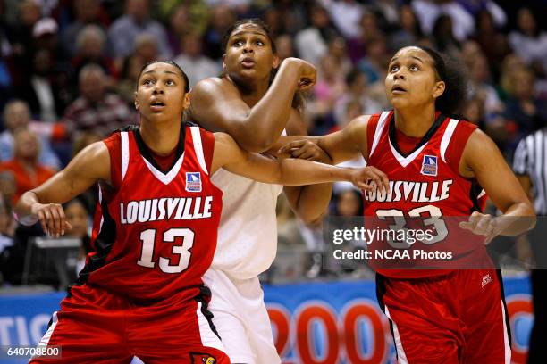 Candyce Bingham and Monique Reid of the University of Louisville box out Courtney Paris of the University of Oklahoma during the Division I Women's...