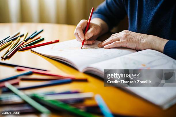 senior woman painting a sketchbook - colored pencils stock pictures, royalty-free photos & images