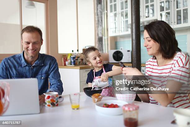 a family taking breakfast in the kitchen - child foodie photos et images de collection