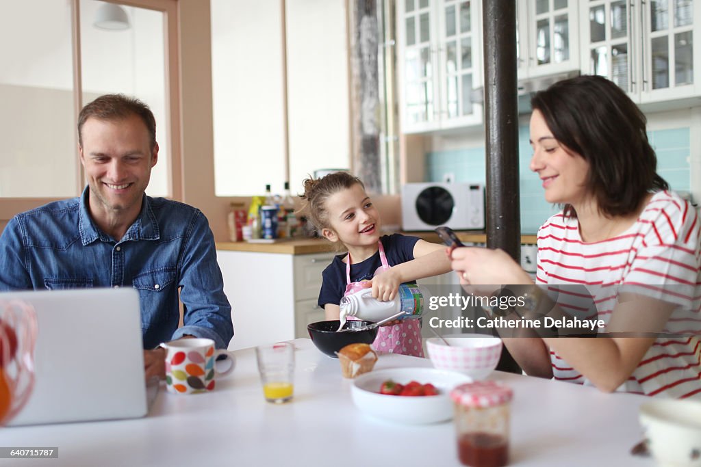 A family taking breakfast in the kitchen