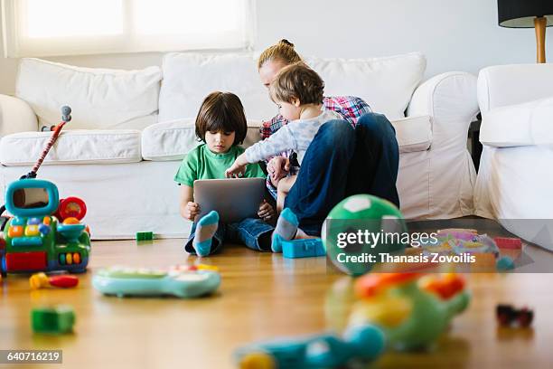 mother with 2 kids using a digital tablet - laminat stock-fotos und bilder