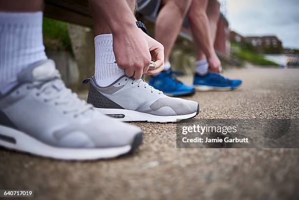 two males tying their shoes preparing for a run - men socks foto e immagini stock