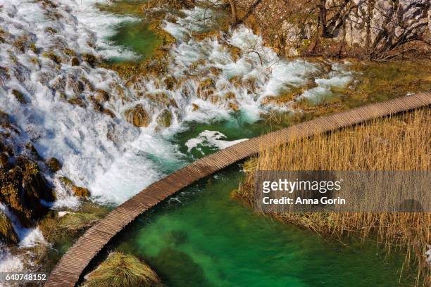 aerial view of deserted boardwalk past waterfalls in plitvice lakes national park, croatia, early spring afternoon - plitvice stock-fotos und bilder