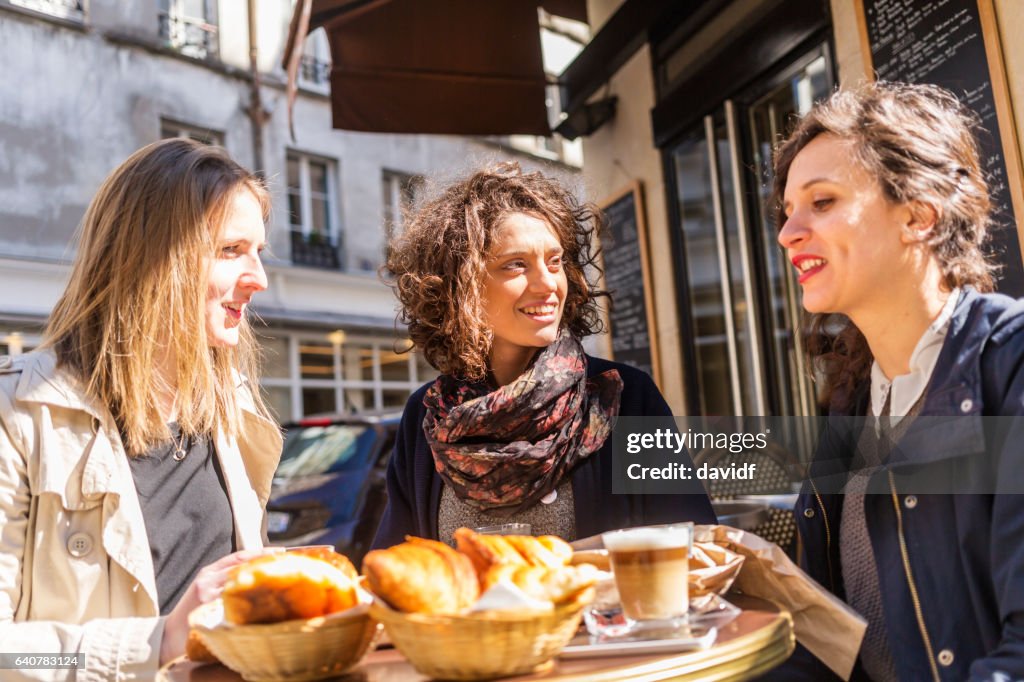 Freunde, die zusammen auf ein französisches Café frühstücken