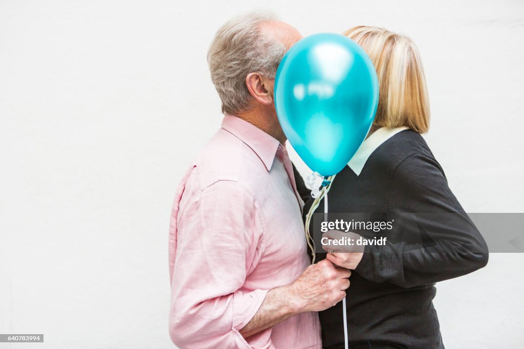 Loving Happy Active Senior Couple Playing With Balloons