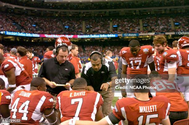 Offensive coordinator Garrick McGee of the University of Arkansas talks with his players as running backs coach Tim Horton looks on during the first...