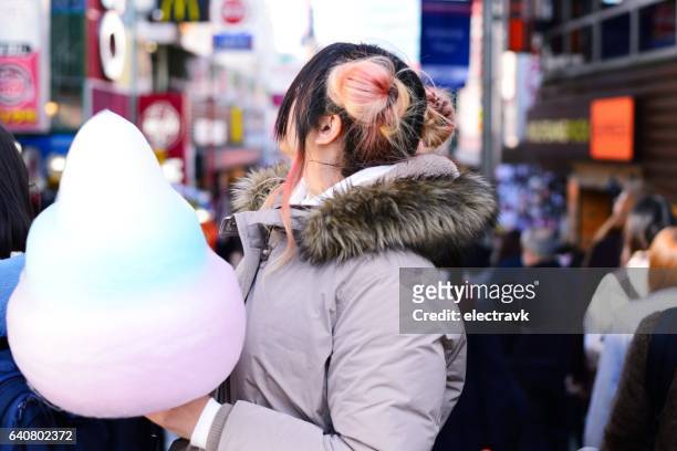 young woman eating cotton candy - harajuku stock pictures, royalty-free photos & images
