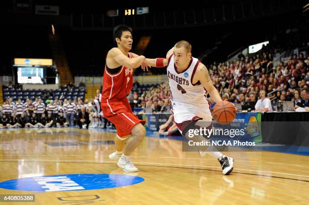 Jeremy Kendle of Bellarmine University drives to the hoop against Jet Chang of BYU-Hawaii during the Division II Men's Basketball Championship held...