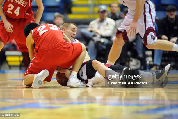 Jeremy Kendle of Bellarmine University and Jet Chang of BYU-Hawaii scramble for a loose ball during the Division II Men's Basketball Championship...