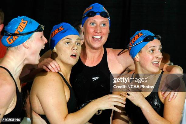 Florida 400 yard freestyle relay swimmers Shara Stafford, left, Jamie Bohunicky, Gemma Spofforth and Elizabeth Kemp react to seeing that their third...