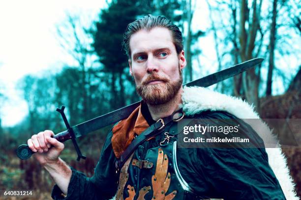 warrior with beard holds on to sword - holding sword stock pictures, royalty-free photos & images