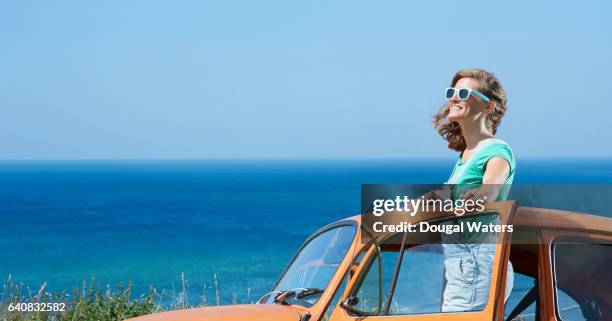 profile of hipster woman on road trip with vintage car and blue sea. - car profile stock pictures, royalty-free photos & images