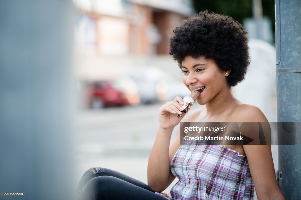 Teenage girl biting chocolate bar