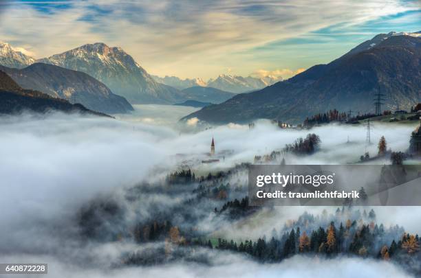 above the fluffly clouds - misty mountains stock-fotos und bilder