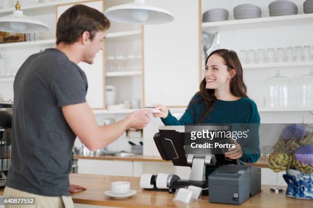 cashier receiving payment from customer in cafe - debit cards credit cards accepted stock pictures, royalty-free photos & images