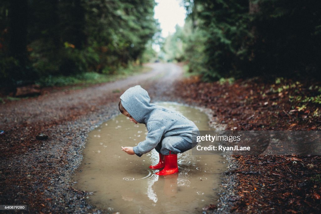Niños jugando en el charco de lluvia