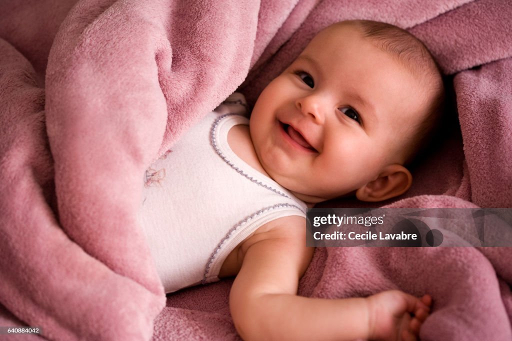 Portrait of baby smiling wrapped in a soft blanket