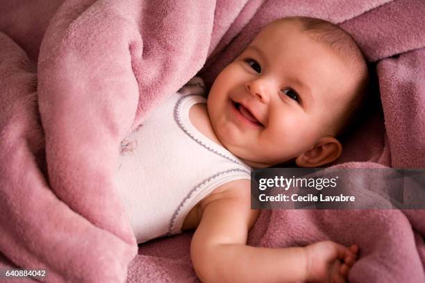 portrait of baby smiling wrapped in a soft blanket - bebés meninas imagens e fotografias de stock